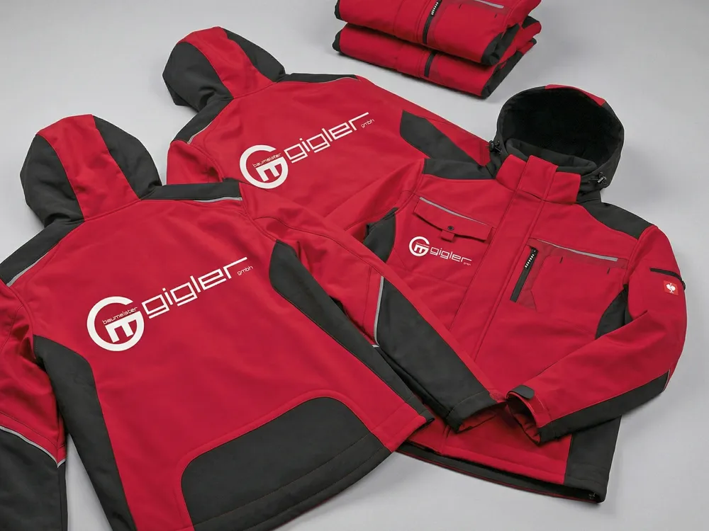 Extrem strapazierfähiges Firmenbranding auf hochwertigen Arbeitsjacken, realisiert durch DTF-Technologie für lange Beständigkeit im harten Berufsalltag.