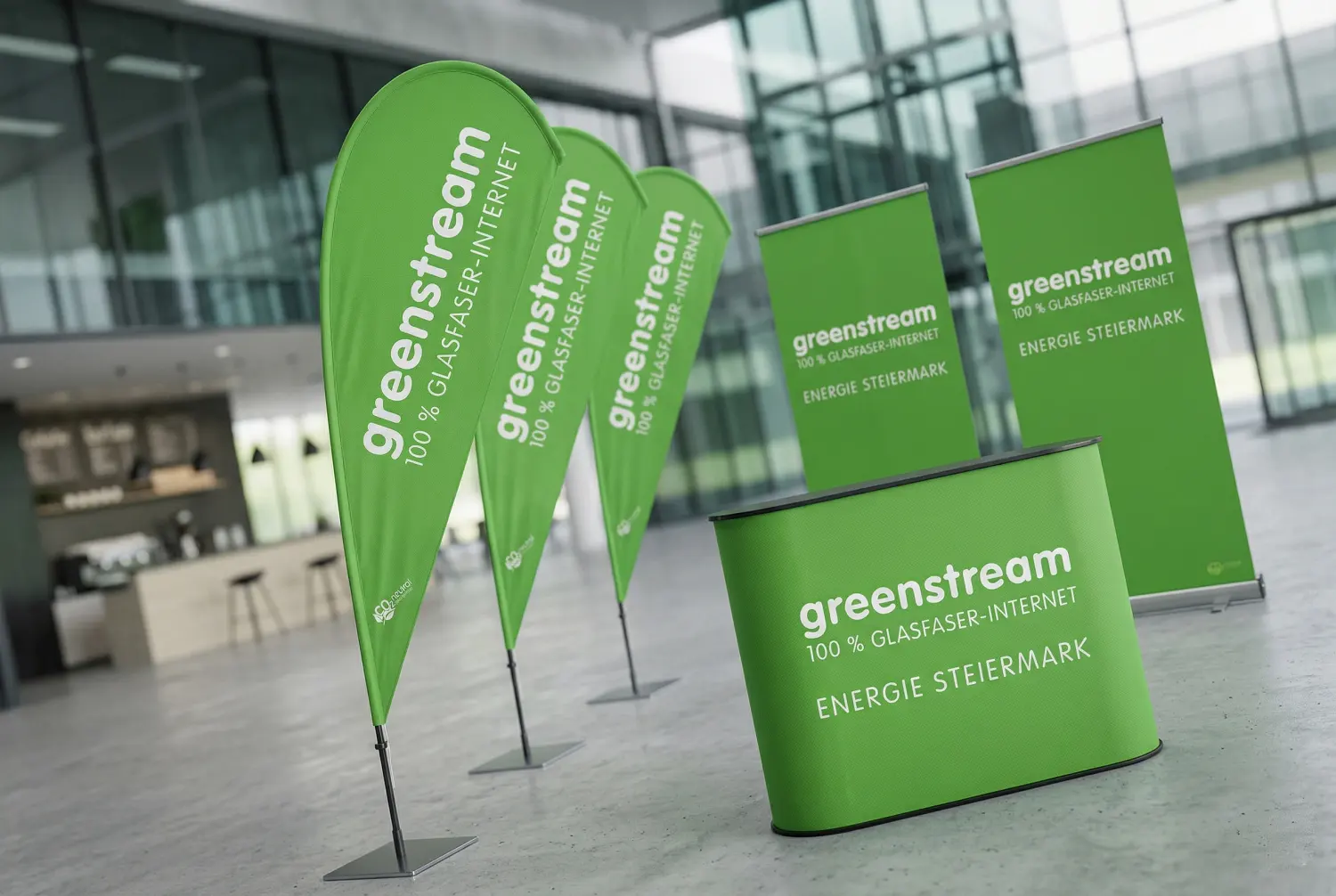 Realisierung der Werbetechnik für Greenstream Energie Steiermark: Professionelle Messeausstattung, Beachflags und Rollups durch die Agentur infinite.